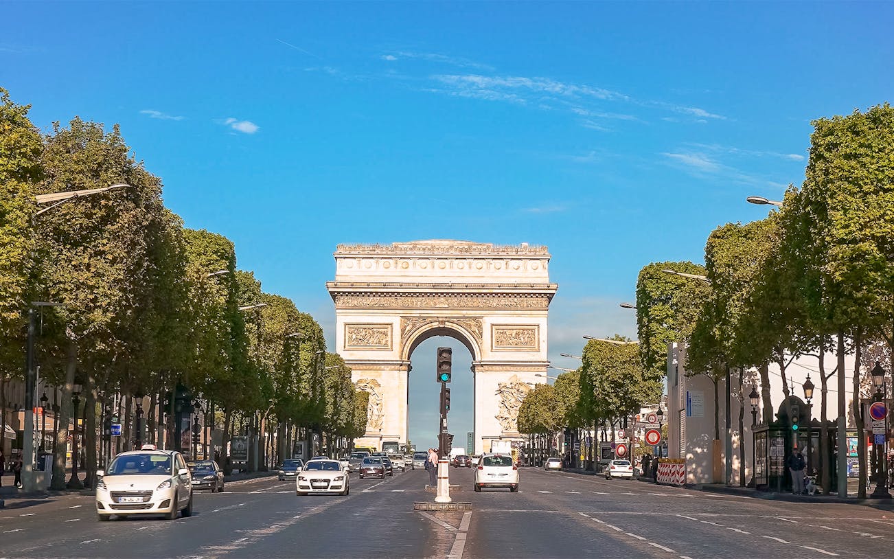 Arc de Triomphe viewed from Champs Elysées, Paris, with cars on the avenue.