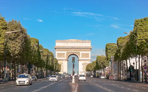 Arc de Triomphe viewed from Champs Elysées, Paris, with cars on the avenue.