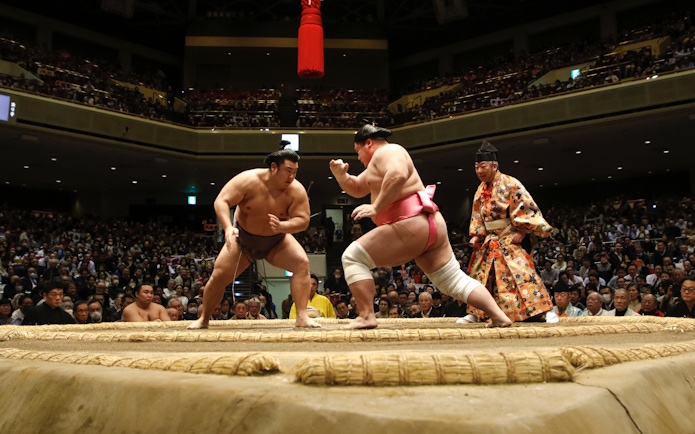 Sumo wrestlers face off in the Nagoya Grand Sumo Tournament arena.