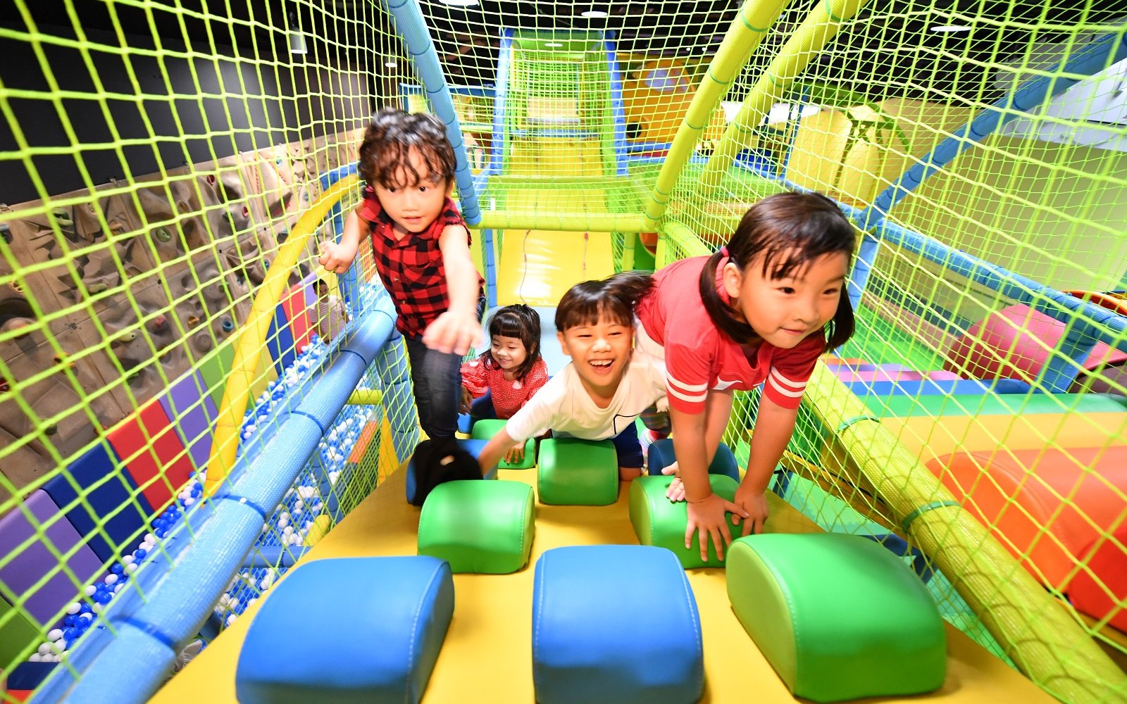 Children climbing play structure at Tayo Station indoor playground.