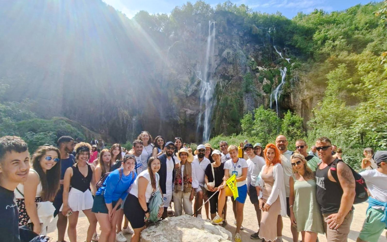 Guests with tour guide at Plitvice Lakes National Park waterfall.
