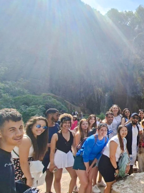 Guests with tour guide at Plitvice Lakes National Park waterfall.
