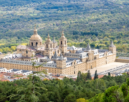 El Escorial Monastery surrounded by lush greenery in San Lorenzo de El Escorial, Spain.