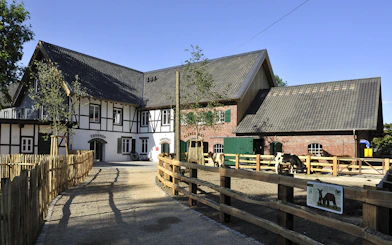 Cologne Zoo Shop exterior with timber-framed building and fenced pathway.