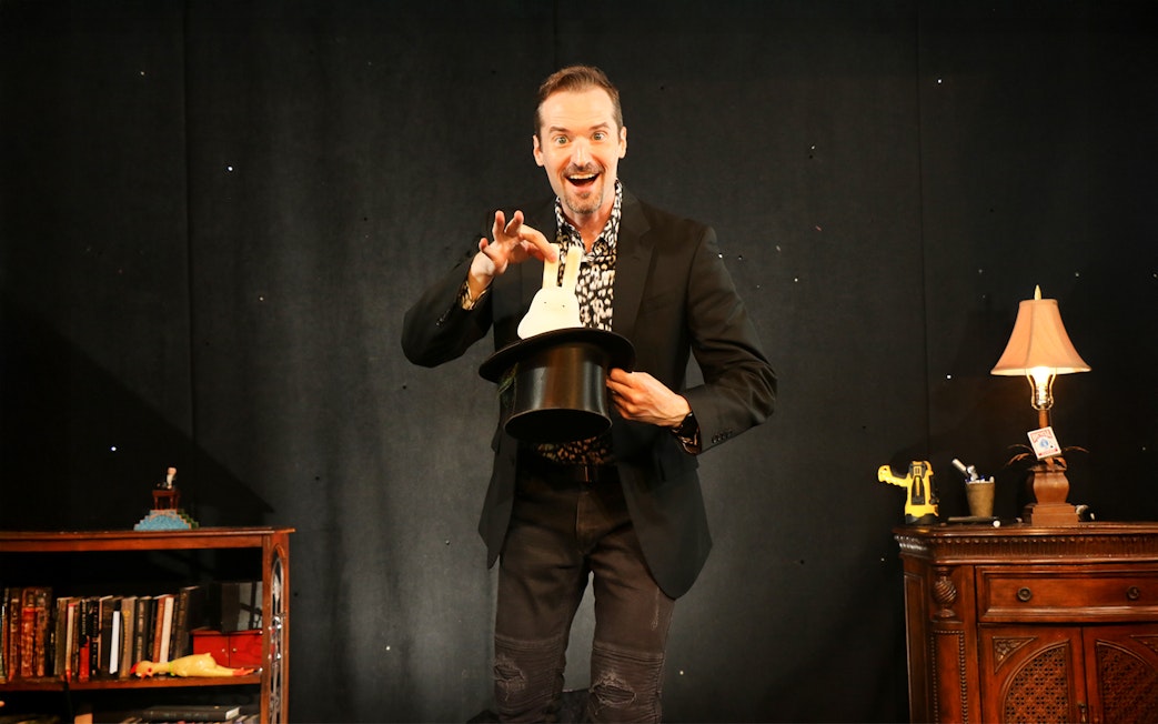 Magician pulling a rabbit from a hat during a show.