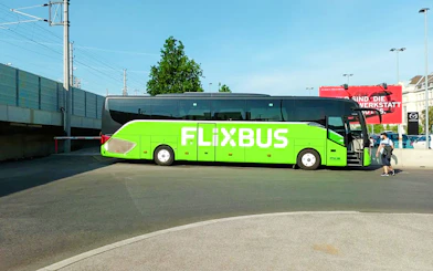 FlixBus parked at a station, offering transport to Efteling from Amsterdam.
