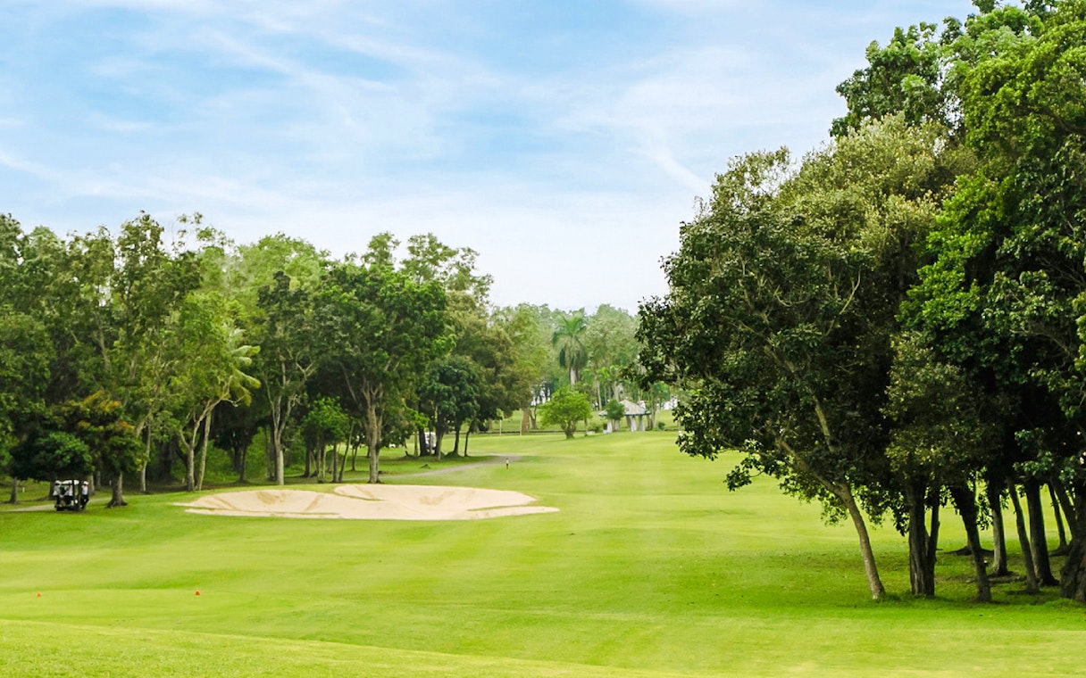 Golf course with sand trap and trees at Batam Island Country Club.