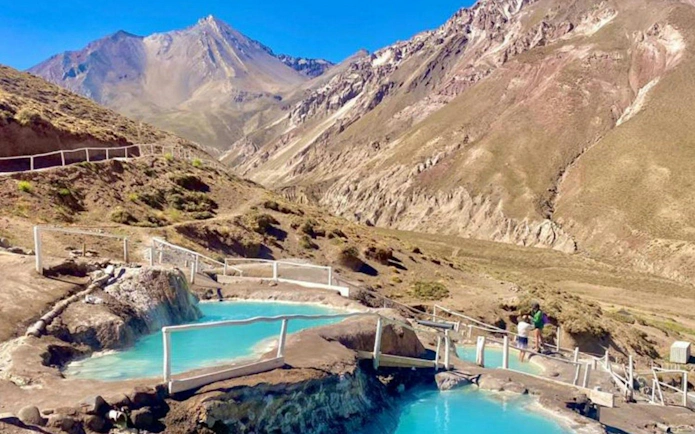 Thermal pools at Termas Colinas with Andes mountains in Cajon del Maipo, Santiago.