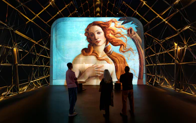Visitors viewing "The Birth of Venus" projection at Fabrique des Lumières exhibit.