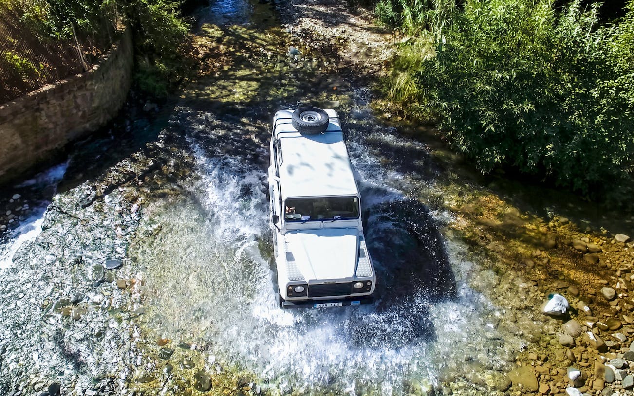 Jeep crossing a stream in the Troodos Mountains, Cyprus during a safari tour.