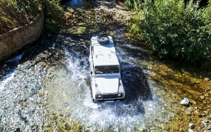 Jeep crossing a stream in the Troodos Mountains, Cyprus during a safari tour.