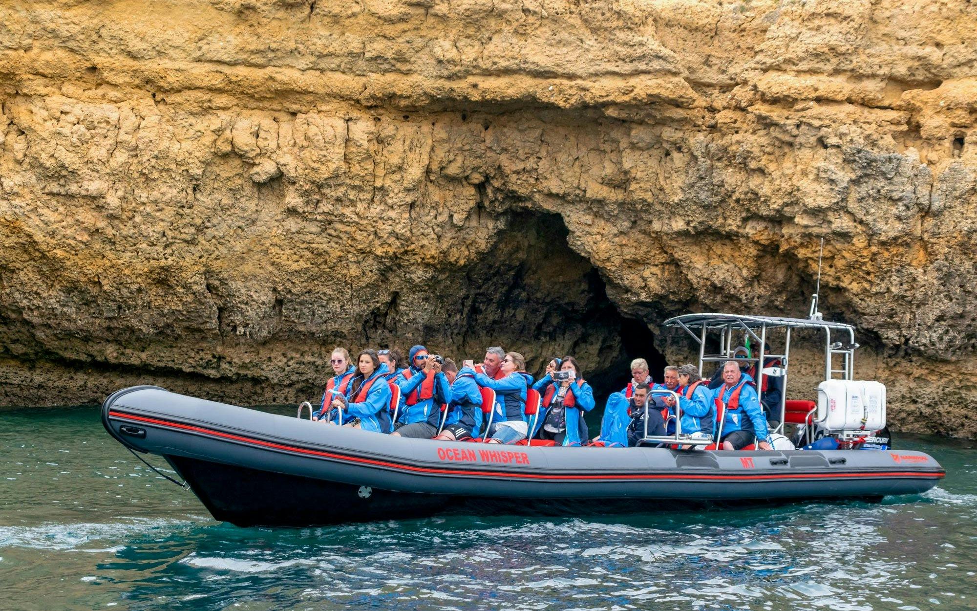 Tourists on RIB boat exploring Benagil Caves, Portugal.