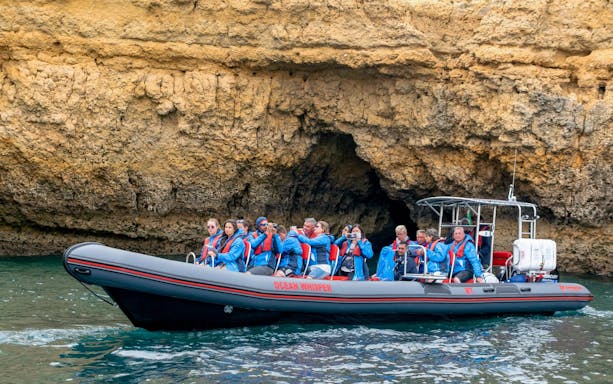 Tourists on RIB boat exploring Benagil Caves, Portugal.