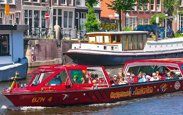 City Sightseeing Amsterdam boat on canal with tourists.