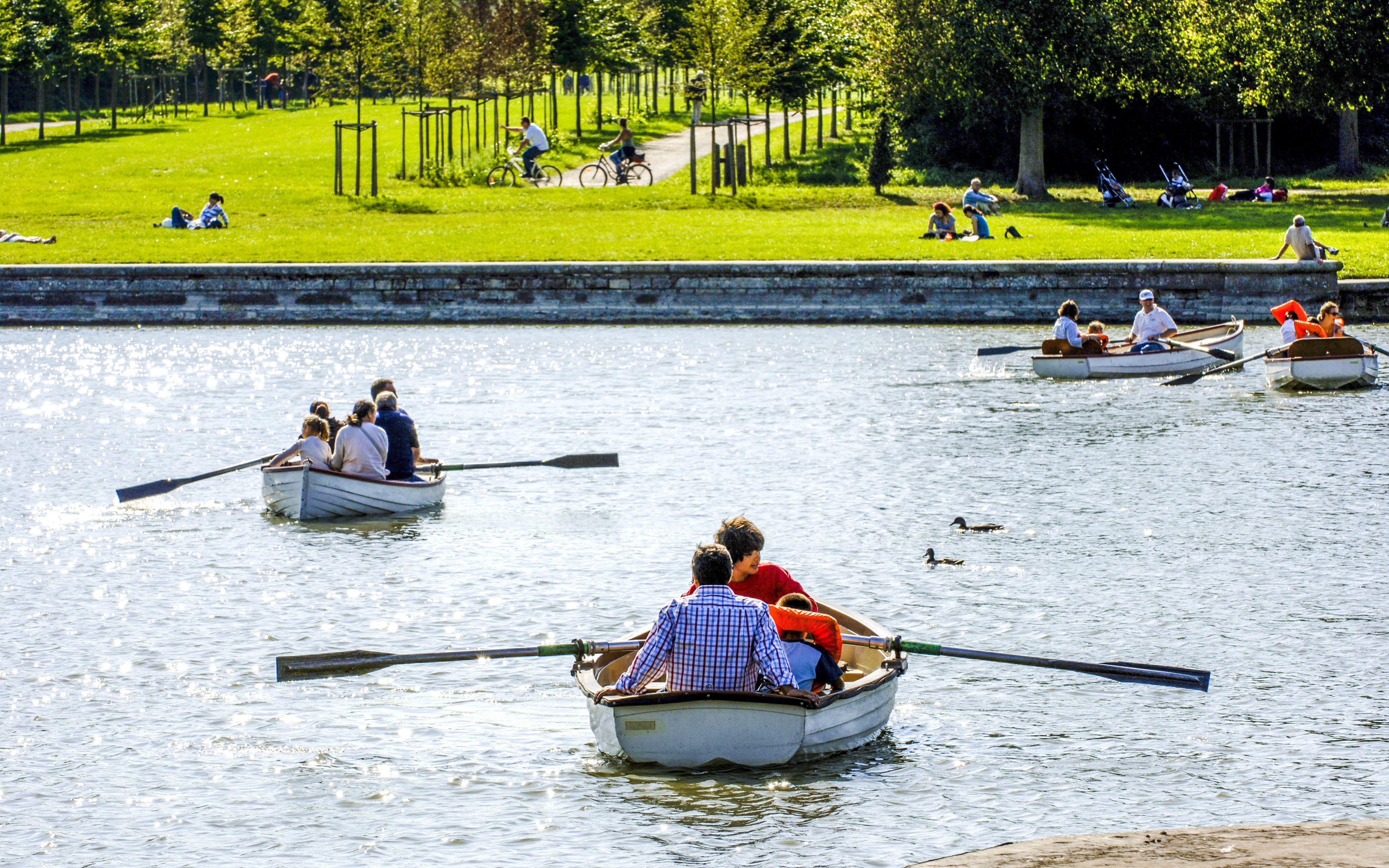 Rowboats on the Grand Canal at Versailles with people rowing and relaxing.