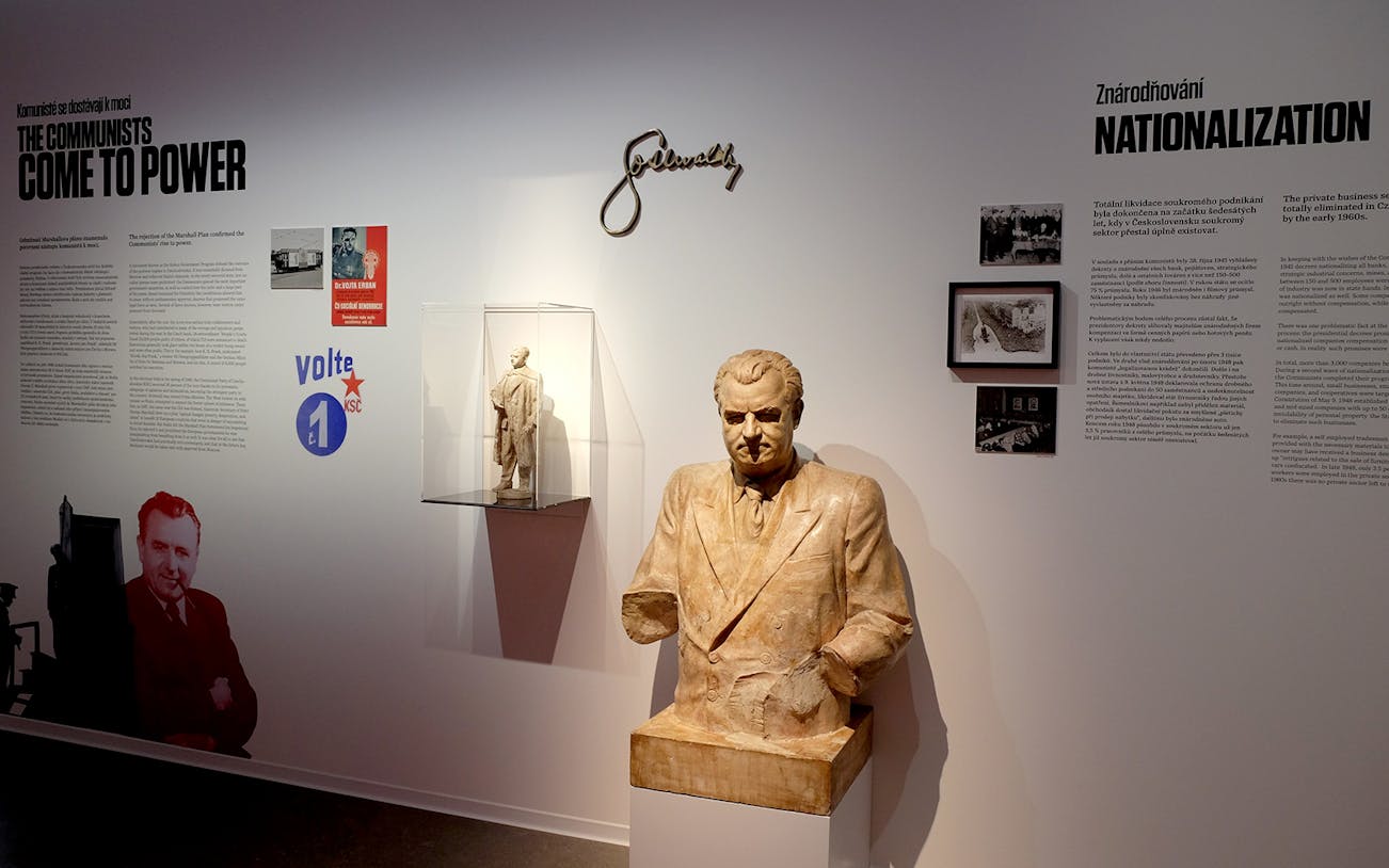 Bust of a communist leader with historical text and images at Museum of Communism, Prague.