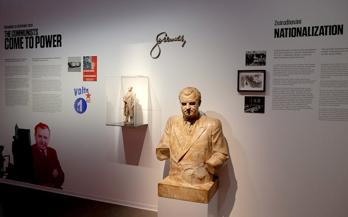 Bust of a communist leader with historical text and images at Museum of Communism, Prague.