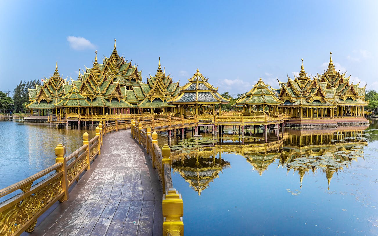 Ancient City Temple with ornate golden roofs over water, Bangkok, Thailand.