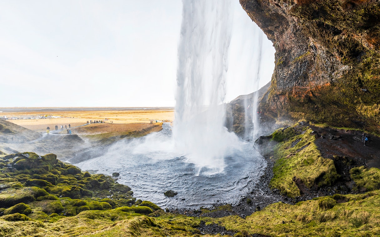 Seljalandsfoss waterfall cascading over mossy cliffs in Southern Iceland.