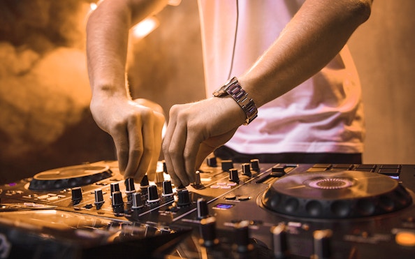 DJ mixing music on a cruise during New Year's Eve dinner event.