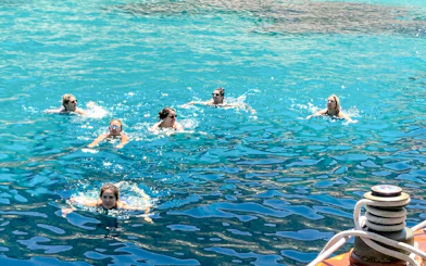 Swimmers enjoying the clear waters near Frioul Archipelago during a Châteaux d’if sailing tour.