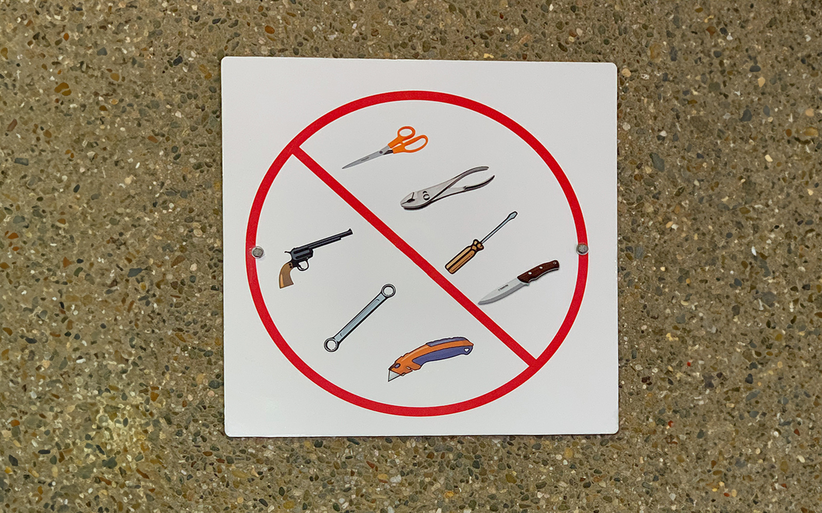 No sharp objects or weapons allowed sign.