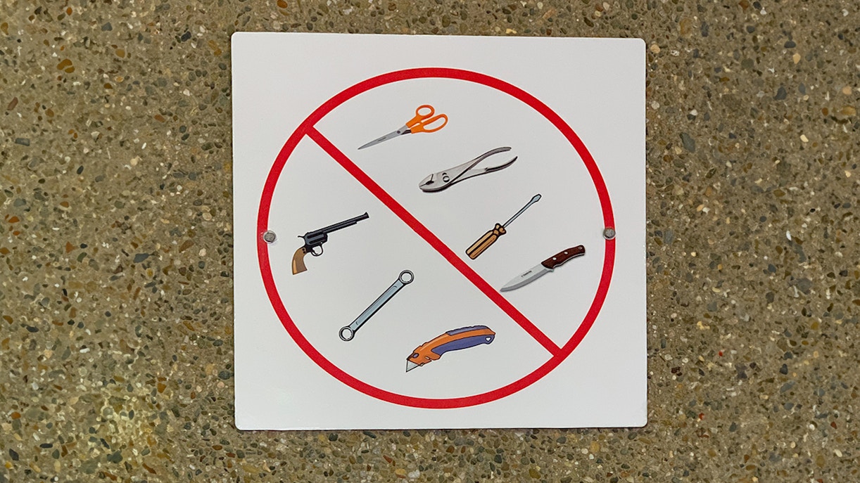 No sharp objects or weapons allowed sign.
