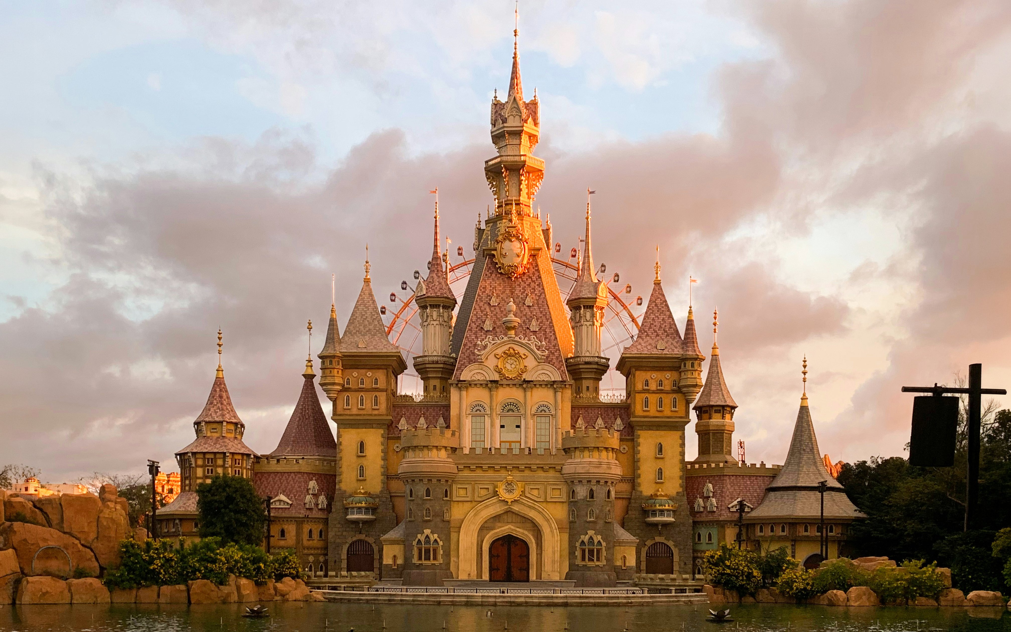 Fairy tale castle at VinWonders Phú Quốc, TP. Phú Quốc, Việt Nam with Ferris wheel in background.