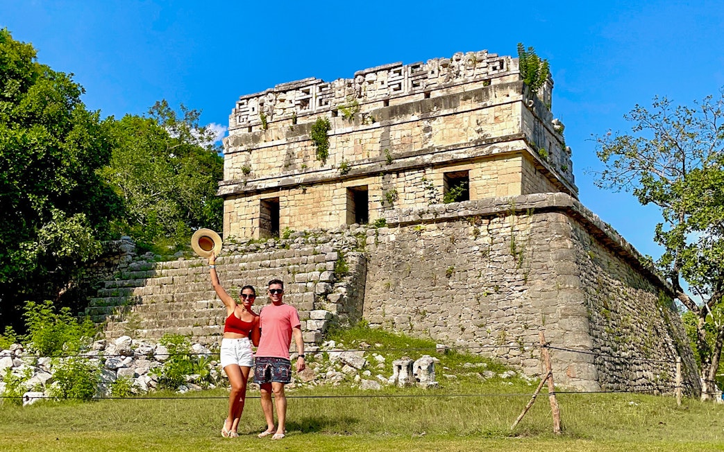 Couple posing in front of Chichen Itza temple, Mexico.