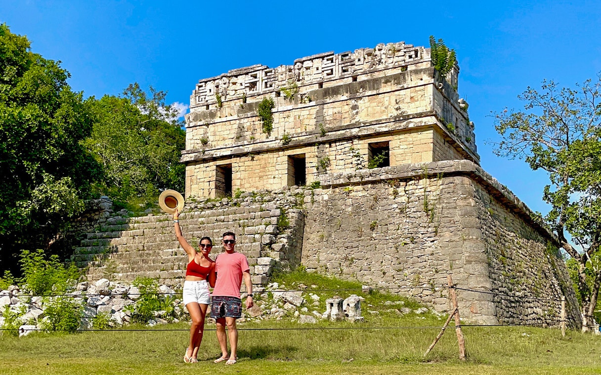 Couple posing in front of Chichen Itza temple, Mexico.