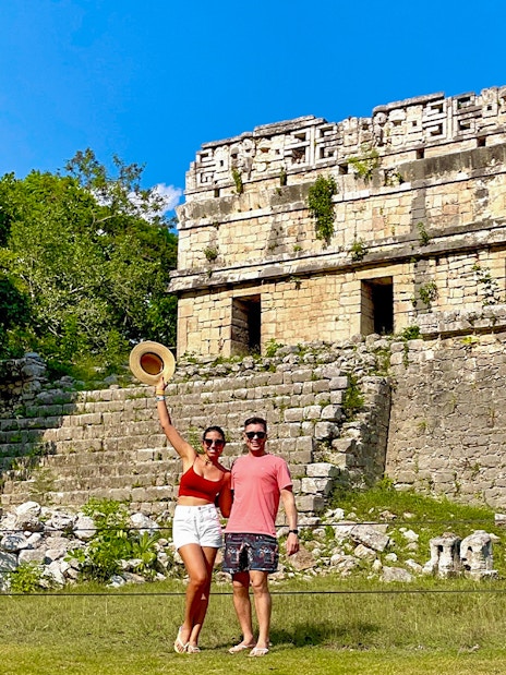 Couple posing in front of Chichen Itza temple, Mexico.