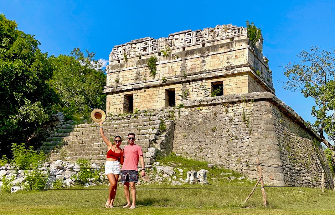 Couple posing in front of Chichen Itza temple, Mexico.
