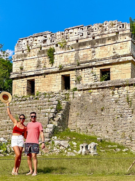 Couple posing in front of Chichen Itza temple, Mexico.