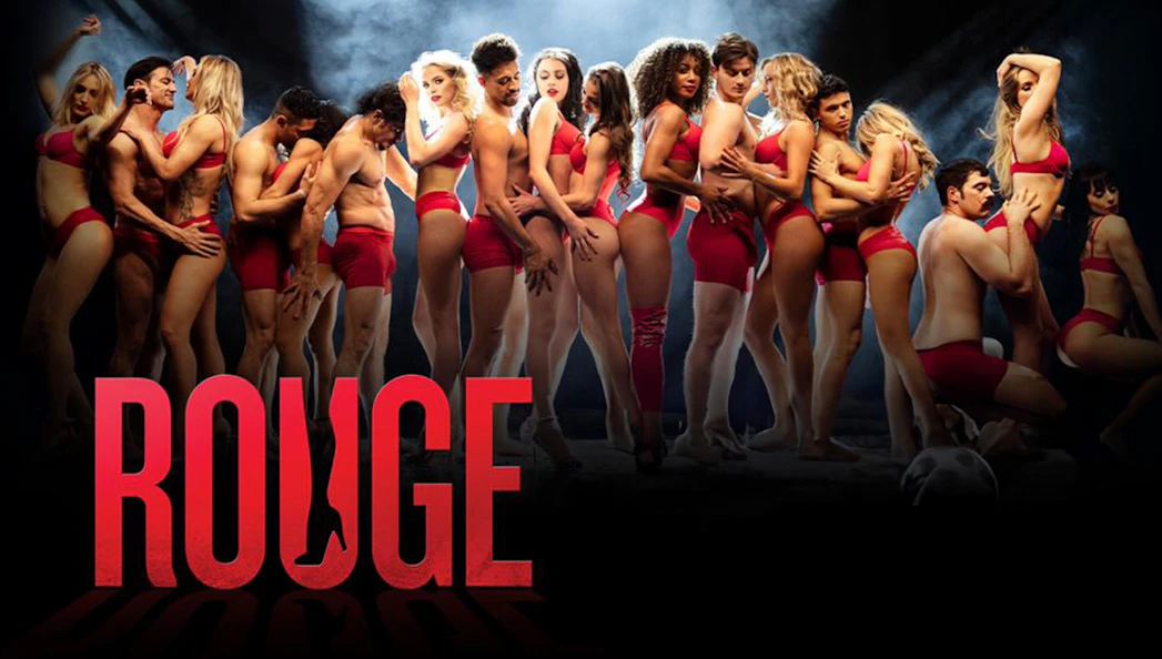 Performers in red outfits on stage for Rouge show.