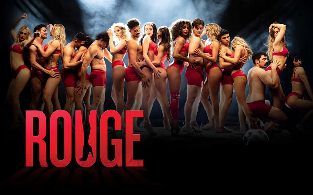 Performers in red outfits on stage for Rouge show.