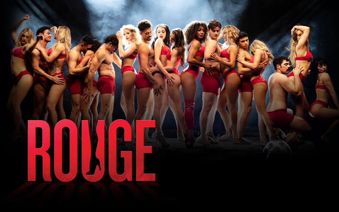 Performers in red outfits on stage for Rouge show.