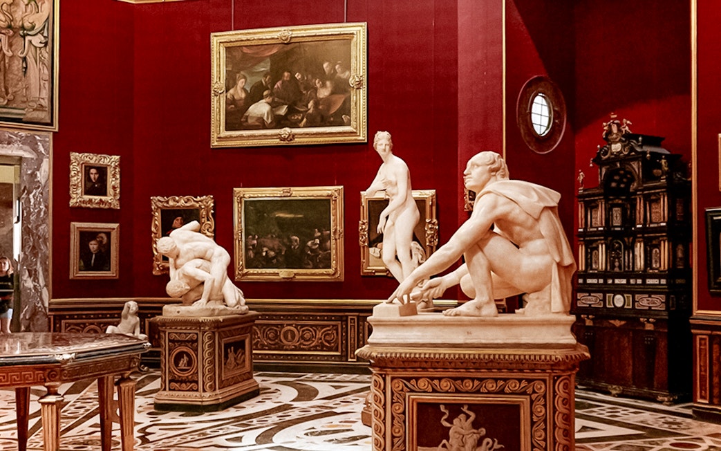 Sculptures and paintings in a gallery room at the Uffizi Gallery, Florence.