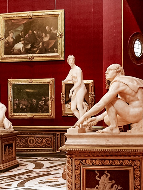 Sculptures and paintings in a gallery room at the Uffizi Gallery, Florence.