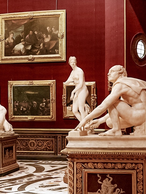 Sculptures and paintings in a gallery room at the Uffizi Gallery, Florence.