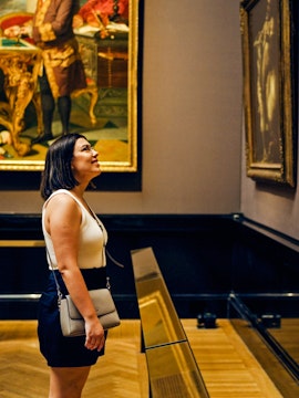 Woman observing paintings in a Vienna art gallery.