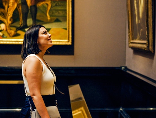 Woman observing paintings in a Vienna art gallery.