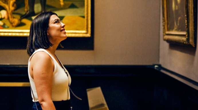 Woman observing paintings in a Vienna art gallery.