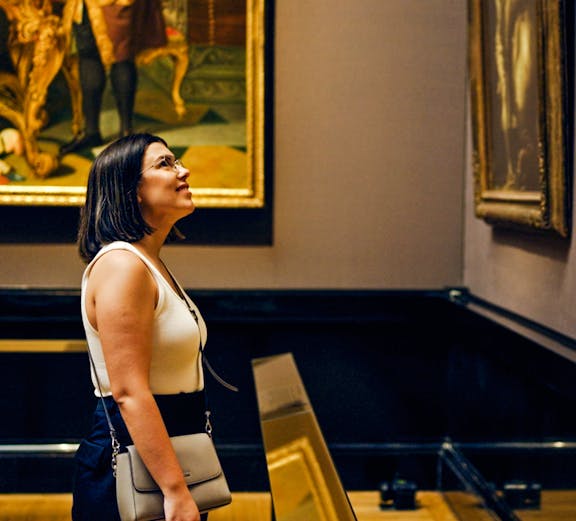 Woman observing paintings in a Vienna art gallery.