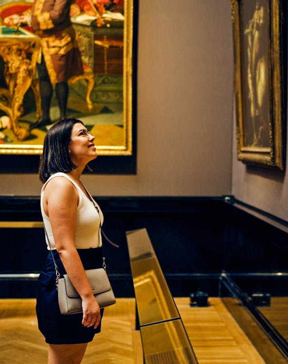 Woman observing paintings in a Vienna art gallery.