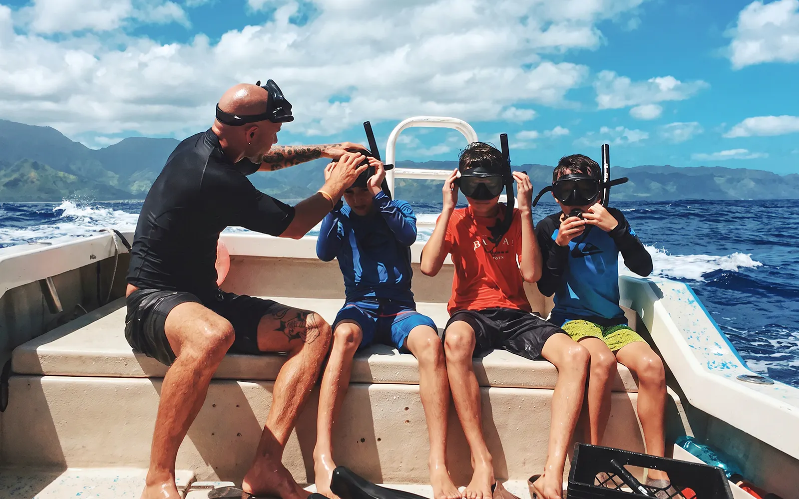 Group preparing for O'ahu shark dive on boat with snorkel gear.
