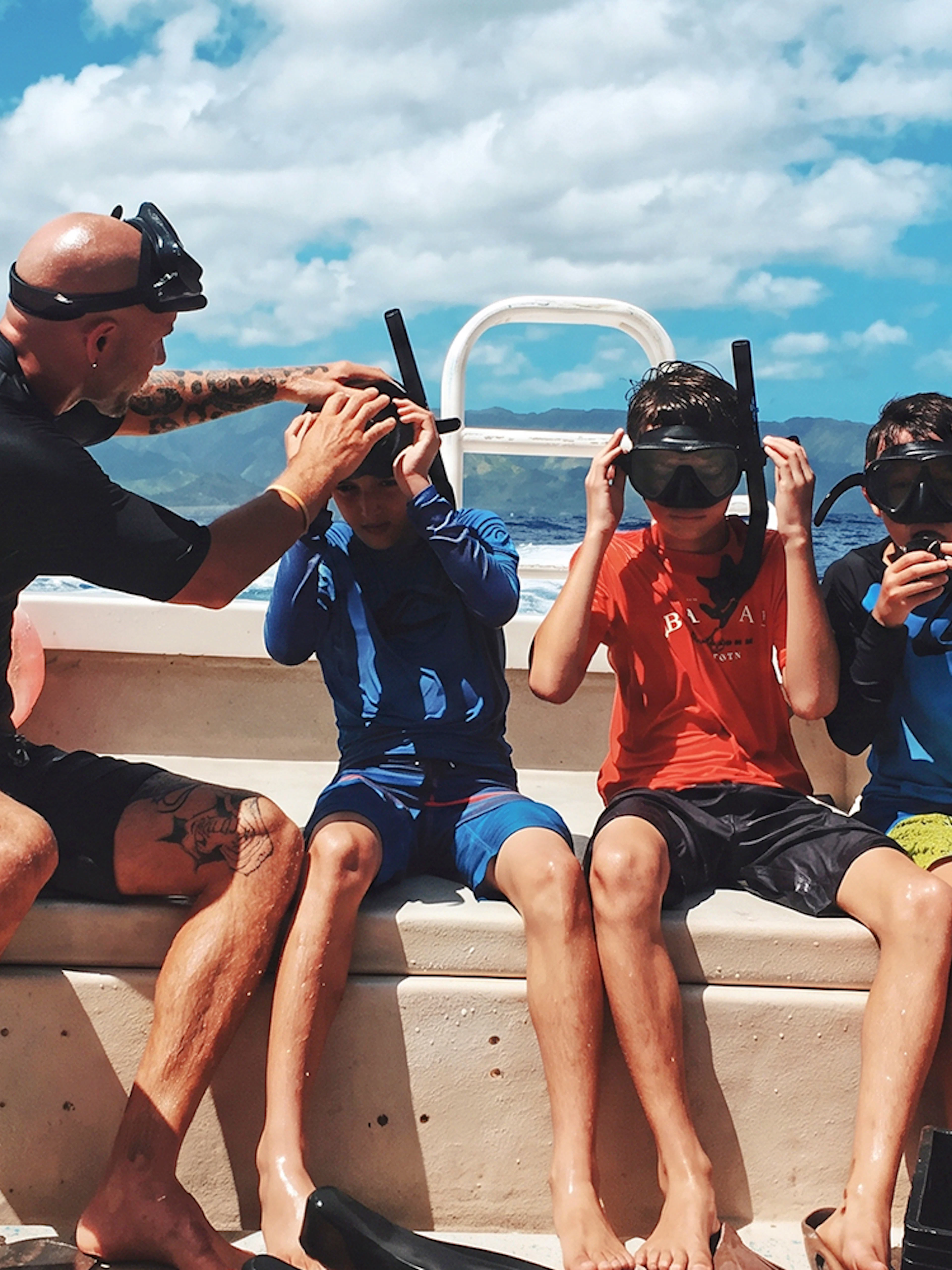Group preparing for O'ahu shark dive on boat with snorkel gear.