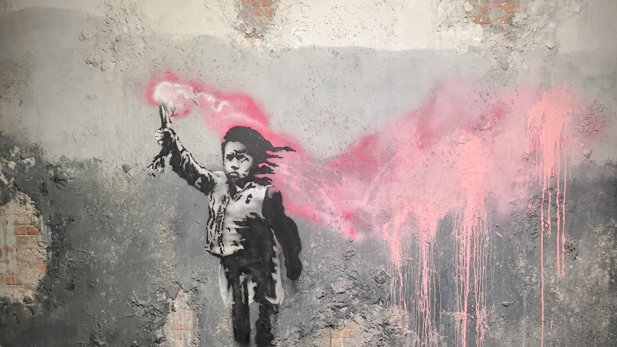 Street art of a child with a pink flare at Banksy Museum, Amsterdam.