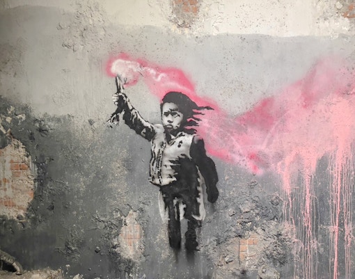 Street art of a child with a pink flare at Banksy Museum, Amsterdam.