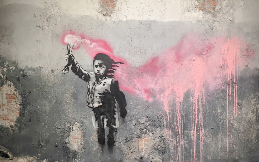 Street art of a child with a pink flare at Banksy Museum, Amsterdam.