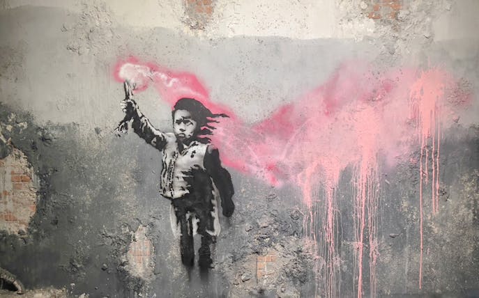 Street art of a child with a pink flare at Banksy Museum, Amsterdam.